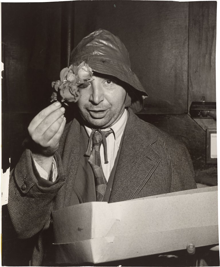 Auf diesem Bild ist das folgende Kunstwerk zu sehen:  Weegee (d.i. Fellig, Arthur H.). The Flower Peddler near the Old Metropolitan Opera House. 1941.