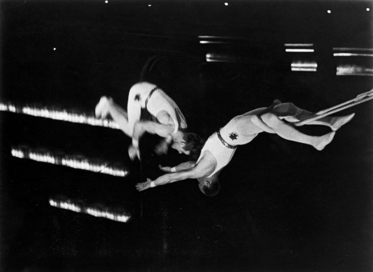 Auf diesem Bild ist das folgende Kunstwerk zu sehen:  Umbo (d.i. Otto Umbehr). Die 3 Codonas während ihrer Arbeit hoch über dem Publikum. Um 1932.