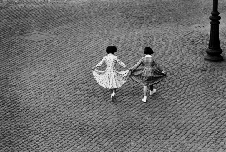 Auf diesem Bild ist das folgende Kunstwerk zu sehen: Herbert List. Blick aus dem Fenster II: Der Tanz der Röcke, Trastevere, Rom. 1953.