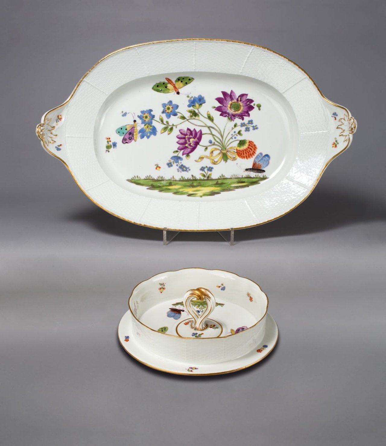 Auf diesem Bild ist das folgende Kunstwerk zu sehen:  Porzellanmanufaktur Meissen. Ovale Platte mit Griffen, Ozier-Relief und Bienenmuster, dazu ein Eiskühler-Deckel aus dem gleichen Service. Um 1740/50.