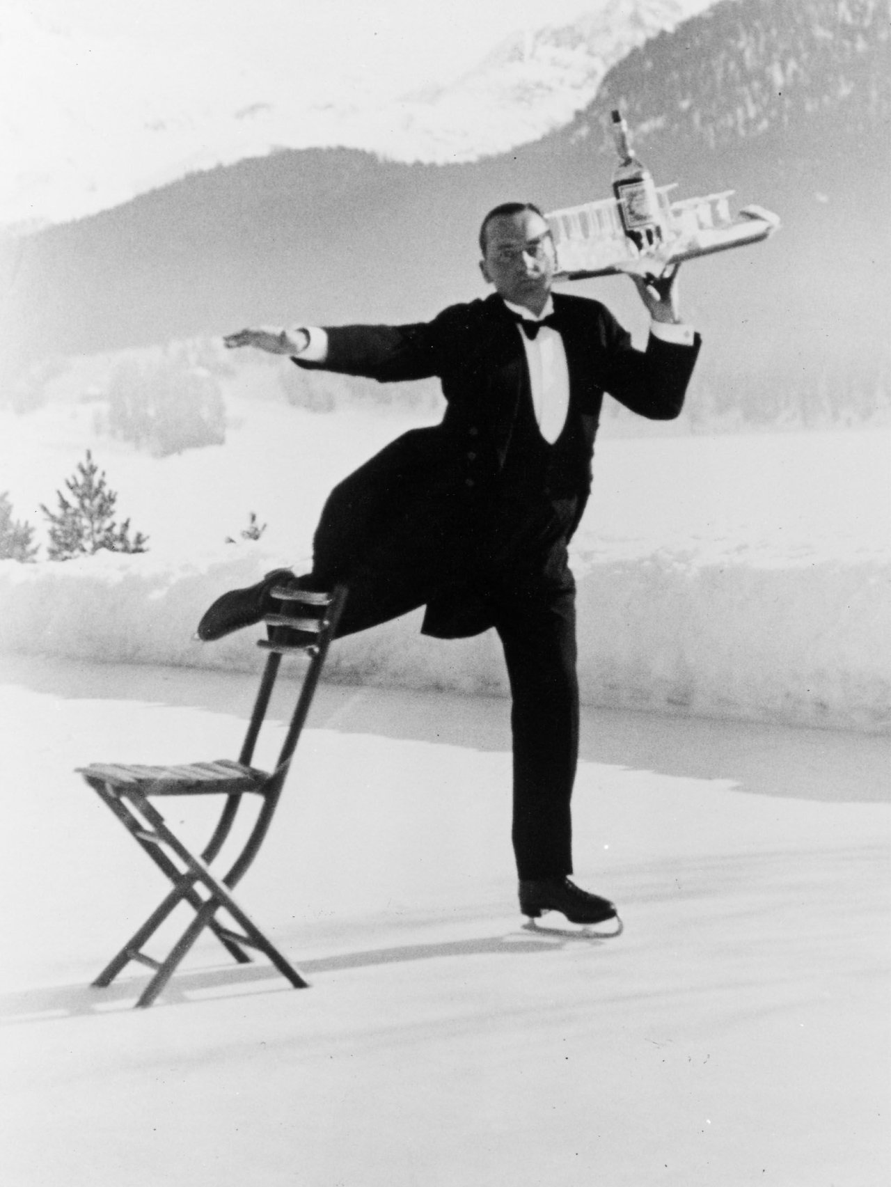 Auf diesem Bild ist das folgende Kunstwerk zu sehen: Alfred Eisenstaedt. Headwaiter René Breguet brings aperitifs to English guests at the skating rink of the Grand Hotel, Saint-Moritz. 1932.