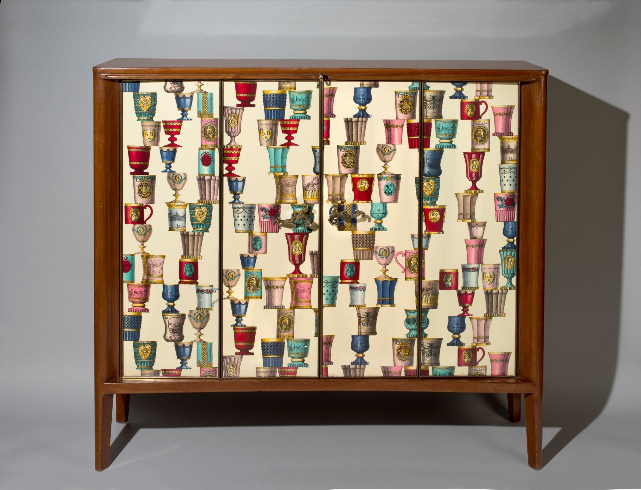 Auf diesem Bild ist das folgende Kunstwerk zu sehen: Osvaldo Borsani und Lucio Fontana. Kabinettschrank (Bar) – mit „Bohemia“-Stoff von Piero Fornasetti (1913–1988). Um 1950.