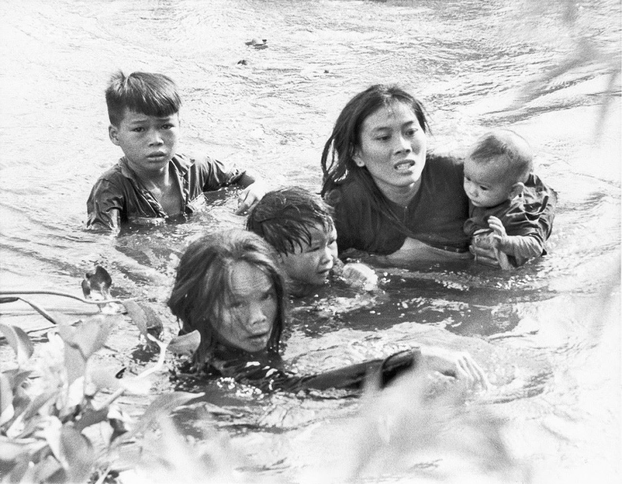 Catalog image of Mother and child struggle to cross river in Vietnam to escape aerial bombardmen…