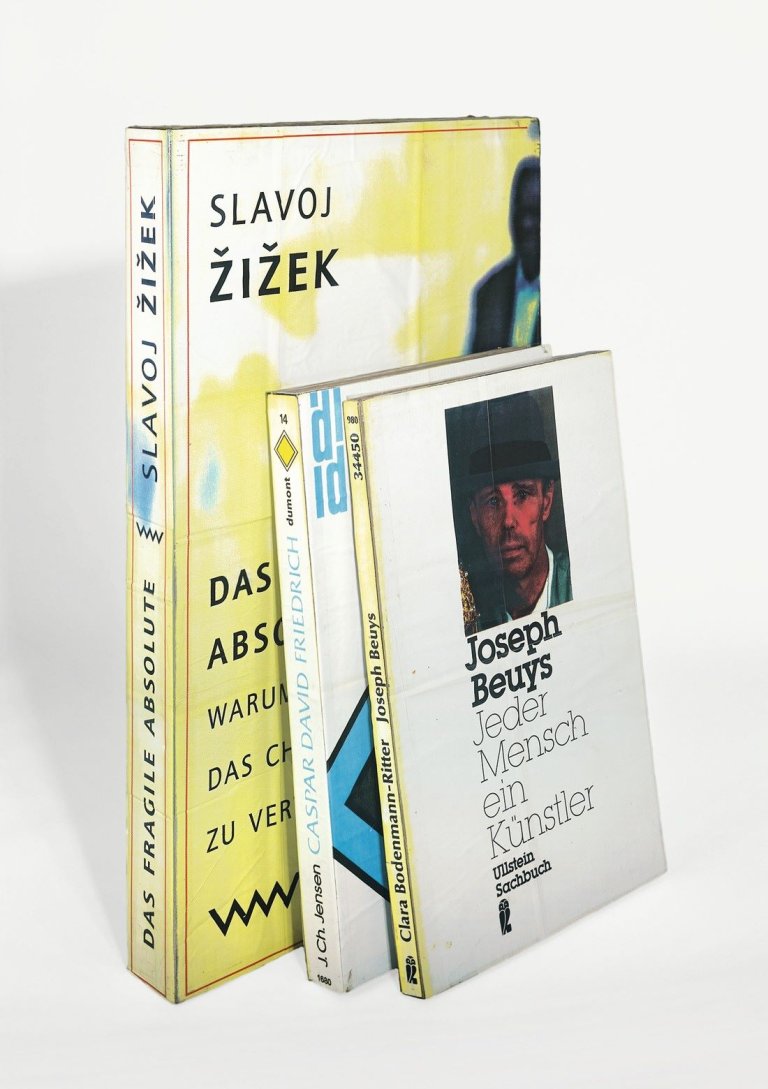 Auf diesem Bild ist das folgende Kunstwerk zu sehen: Thomas Hirschhorn. Joseph Beuys: Jeder Mensch ein Künstler / Slavoj Zizek: Das fragile Absolute / Jens Christian Jensen: Caspar David Friedrich (aus: „Emergency Library“). 2003.