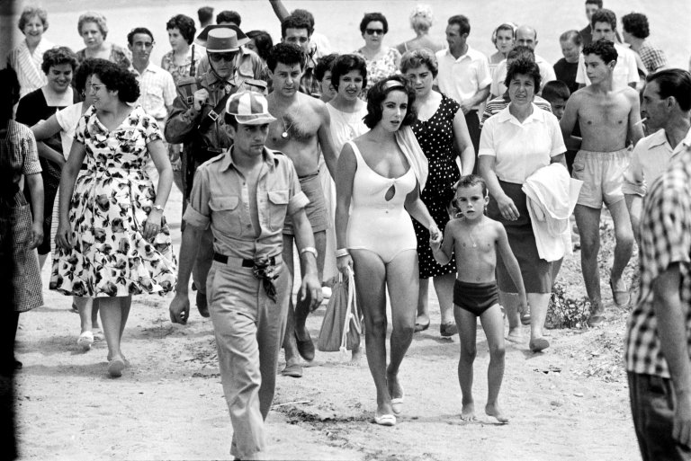 Auf diesem Bild ist das folgende Kunstwerk zu sehen: Burt Glinn. Elizabeth Taylor with her son Christopher while shooting the film „Suddenly Last Summer“, S‘Agaró, Spanien. 1959.