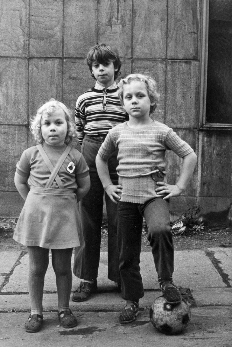 Auf diesem Bild ist das folgende Kunstwerk zu sehen: Helga Paris. Ohne Titel (Drei Kinder), aus: Häuser und Gesichter, Halle. 1983–1985.
