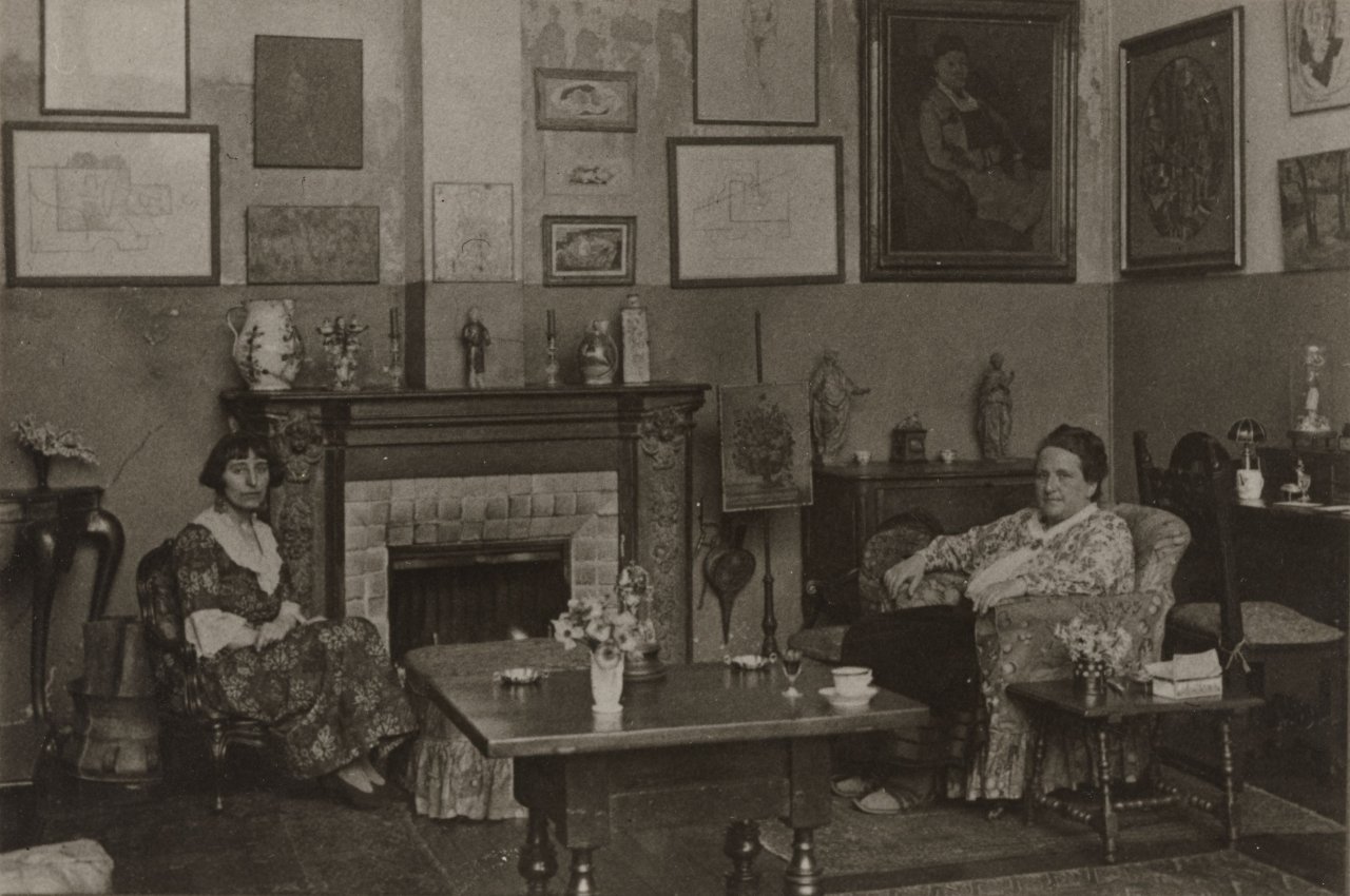 Auf diesem Bild ist das folgende Kunstwerk zu sehen:  Man Ray. Gertrude Stein und Alice B. Toklas, Salon Rue de Fleurus Nr. 27, Paris. 1922.
