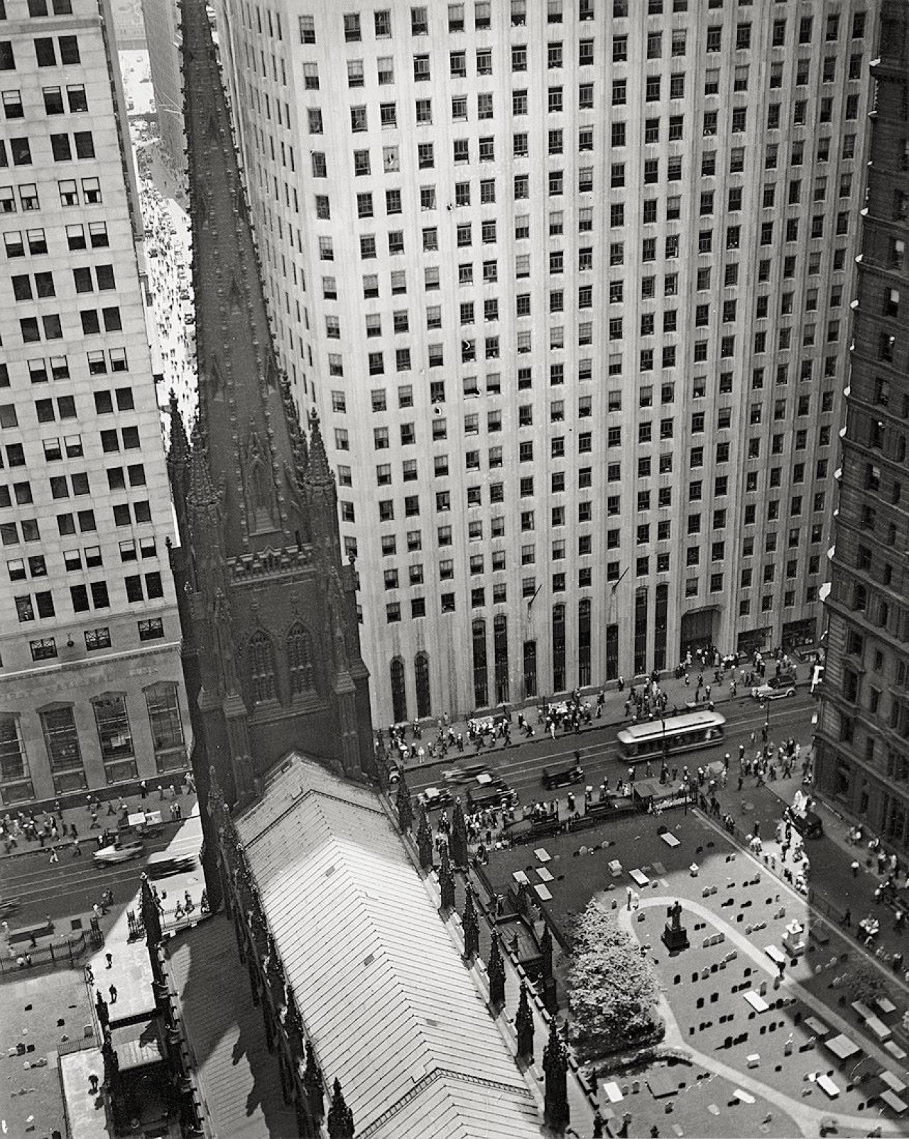 Auf diesem Bild ist das folgende Kunstwerk zu sehen: Berenice Abbott. Trinity Churchyard looking down Wall Street, New York City. Um 1938.
