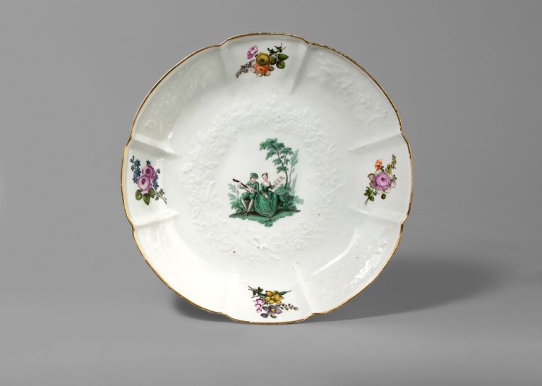 Auf diesem Bild ist das folgende Kunstwerk zu sehen:  Porzellanmanufaktur Meissen. Schüssel mit Gotzkowsky-Relief und kupfergrüner Watteauszene, Blumendekor und goldenem Rand. Um 1750.