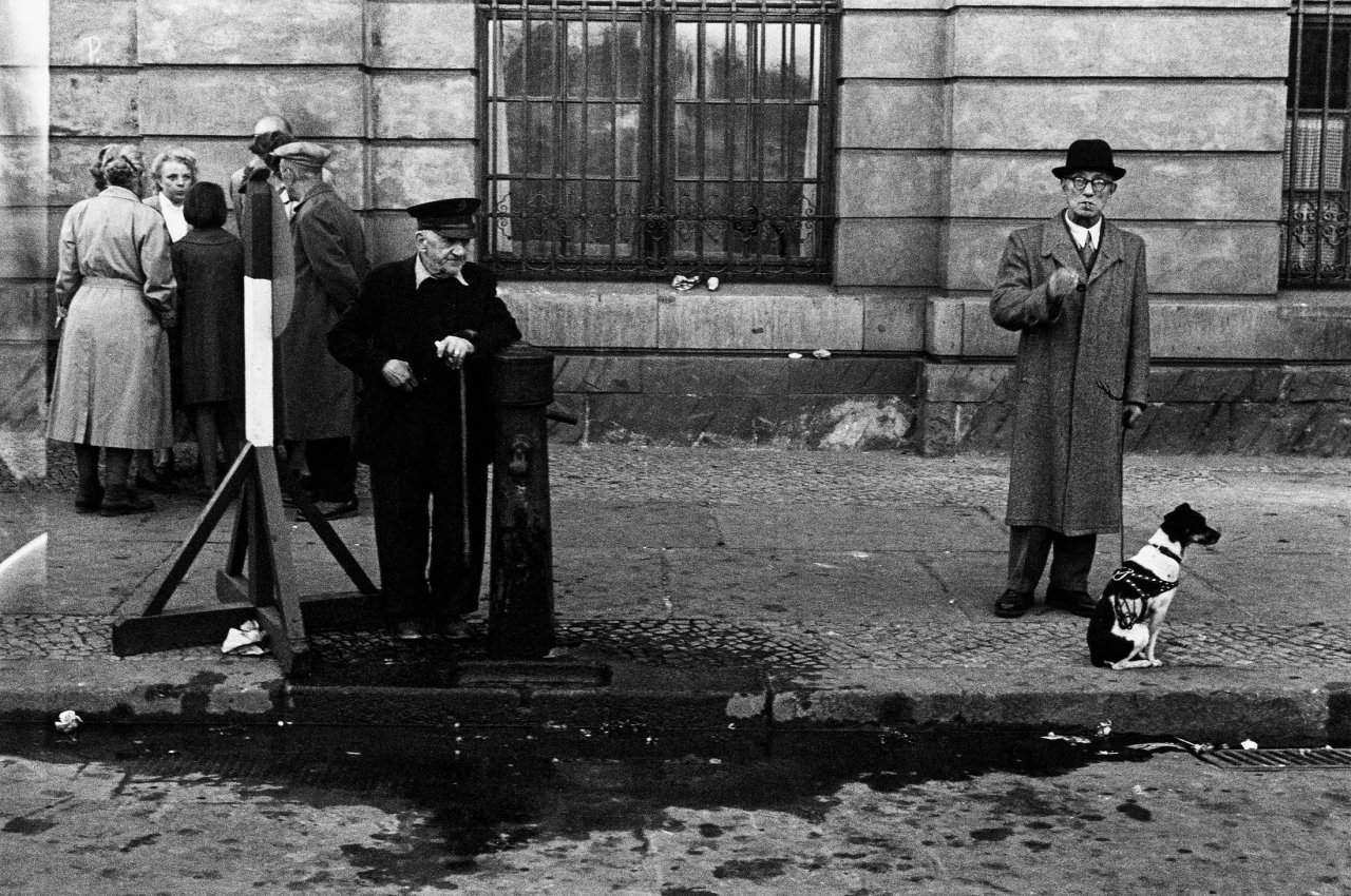 Auf diesem Bild ist das folgende Kunstwerk zu sehen: Will McBride. „Mann mit Hund, Ost Berlin Gruppe“. 1956.