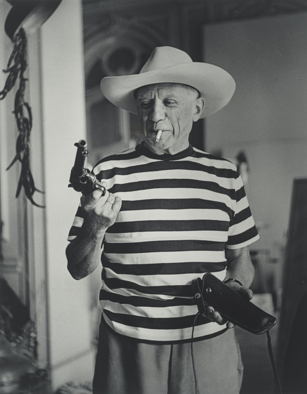 Auf diesem Bild ist das folgende Kunstwerk zu sehen: André Villers. „Picasso avec le Chapeau et le Colt offerts par Gary Cooper, Cannes“. 1959.