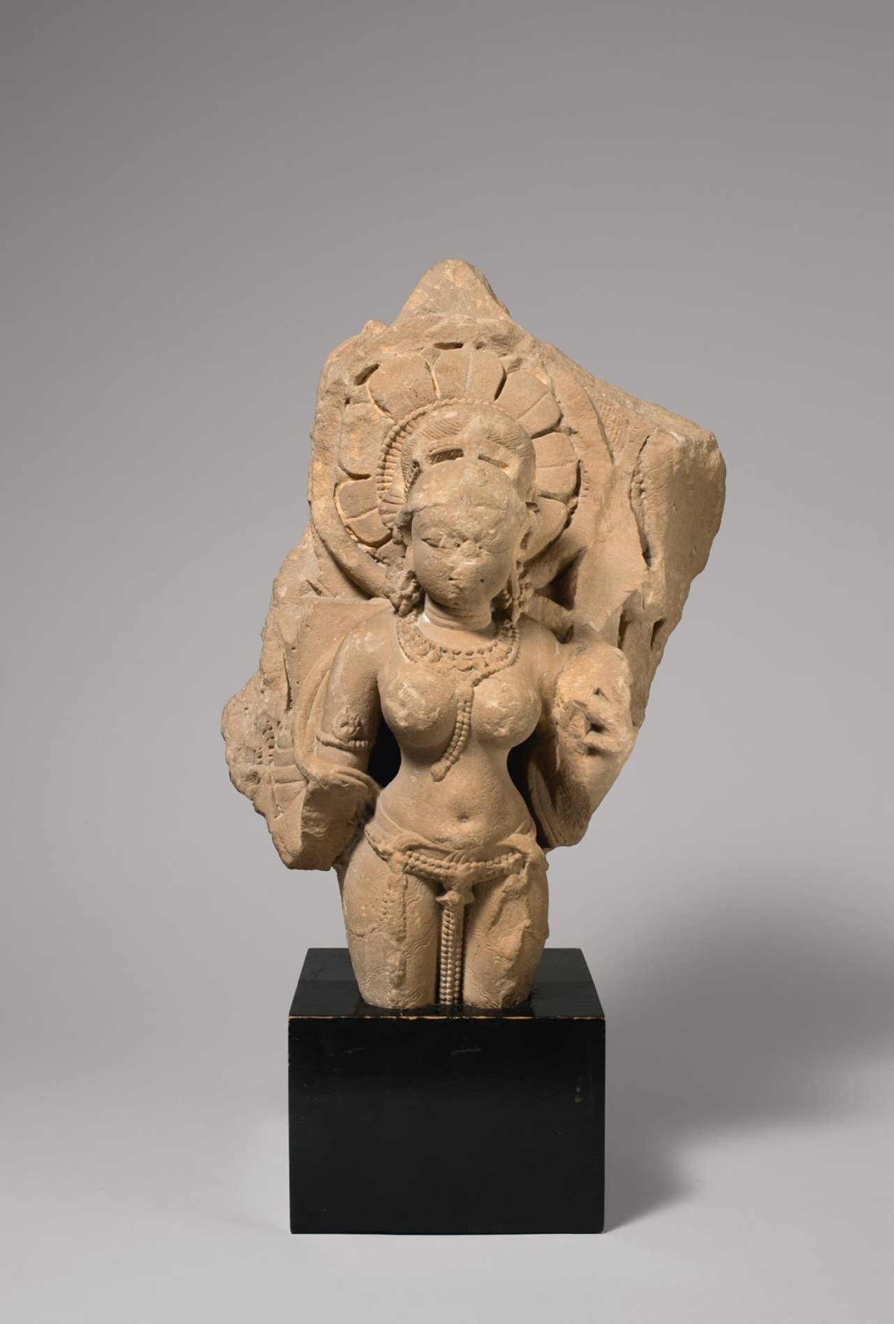 Auf diesem Bild ist das folgende Kunstwerk zu sehen:  Indisch. Relieffragment einer weiblichen Gottheit, wohl Shiva. 10./11. Jahrhundert.