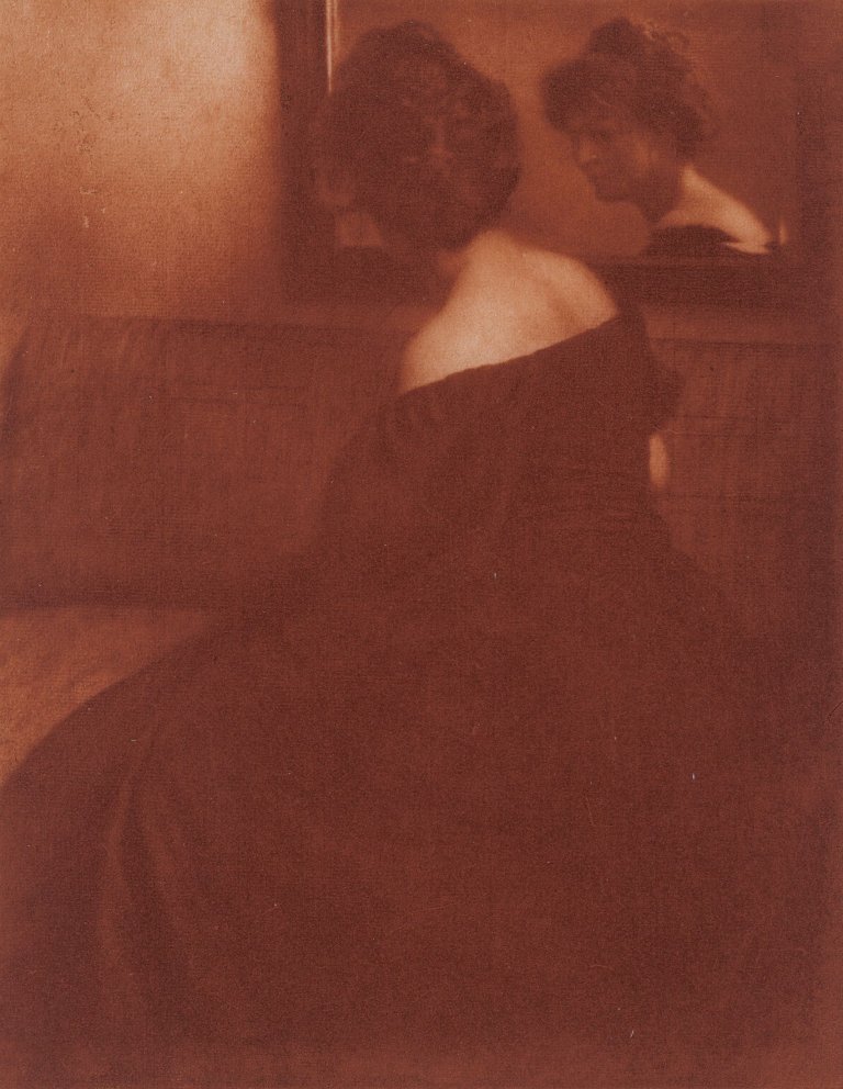 Auf diesem Bild ist das folgende Kunstwerk zu sehen: Heinrich Kühn. Dame vor dem Spiegel. Um 1904.
