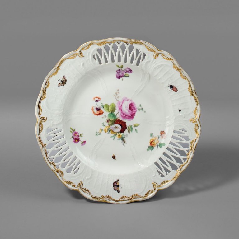 Auf diesem Bild ist das folgende Kunstwerk zu sehen:  KPM Königliche Porzellan-Manufaktur Berlin. Dessertteller aus dem dritten Tafelservice für König Friedrich den Großen – Reliefzierrat mit Spalier, Lanzettdurchbrüchen, Blumenmalerei und goldener Laubkante für das Berliner Schloß. 1773.