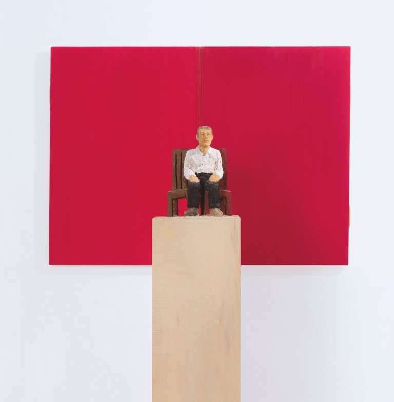 Auf diesem Bild ist das folgende Kunstwerk zu sehen: Stephan Balkenhol. Mann zwischen zwei Stühlen. 2005.