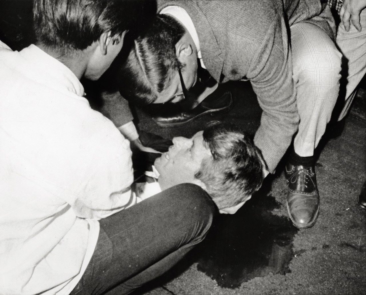 Auf diesem Bild ist das folgende Kunstwerk zu sehen: Ron Bennett. Critically wounded. Senator Robert F. Kennedy lies on the floor / Suspect in the shooting of Sen. Robert Kenndey / Hustled to jail. 1968.