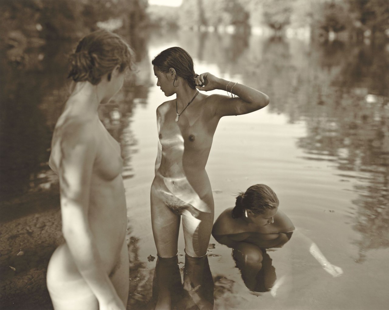 Auf diesem Bild ist das folgende Kunstwerk zu sehen: Jock Sturges. „Vanessa, Fanny et Camille; La rivière Dronne, Les Peintures, France“. 2001.