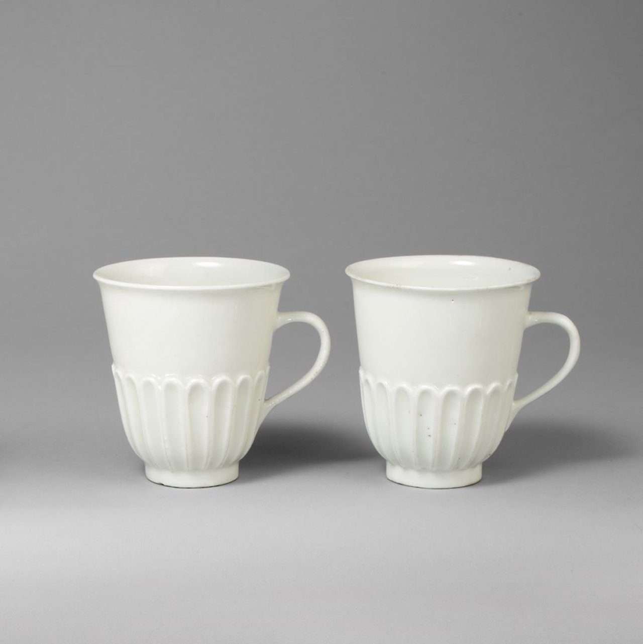 Auf diesem Bild ist das folgende Kunstwerk zu sehen:  Porzellanmanufaktur Meissen. Zwei Henkelbecher mit Rillendekor. Um 1715/20.