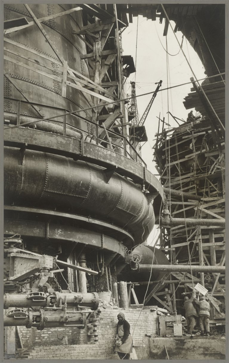 Auf diesem Bild ist das folgende Kunstwerk zu sehen: Margaret Bourke-White. „Miloff Helps – along 'The Looming World October'. Five Year Plan, Russia“. 1931.