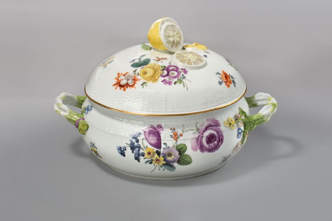 Auf diesem Bild ist das folgende Kunstwerk zu sehen:  Porzellanmanufaktur Meissen. Große runde Terrine mit Ozier-Relief, Deutschen Blumen, Spargelgriffen, Zitronenknauf und goldener Randkante. Um 1745/50.