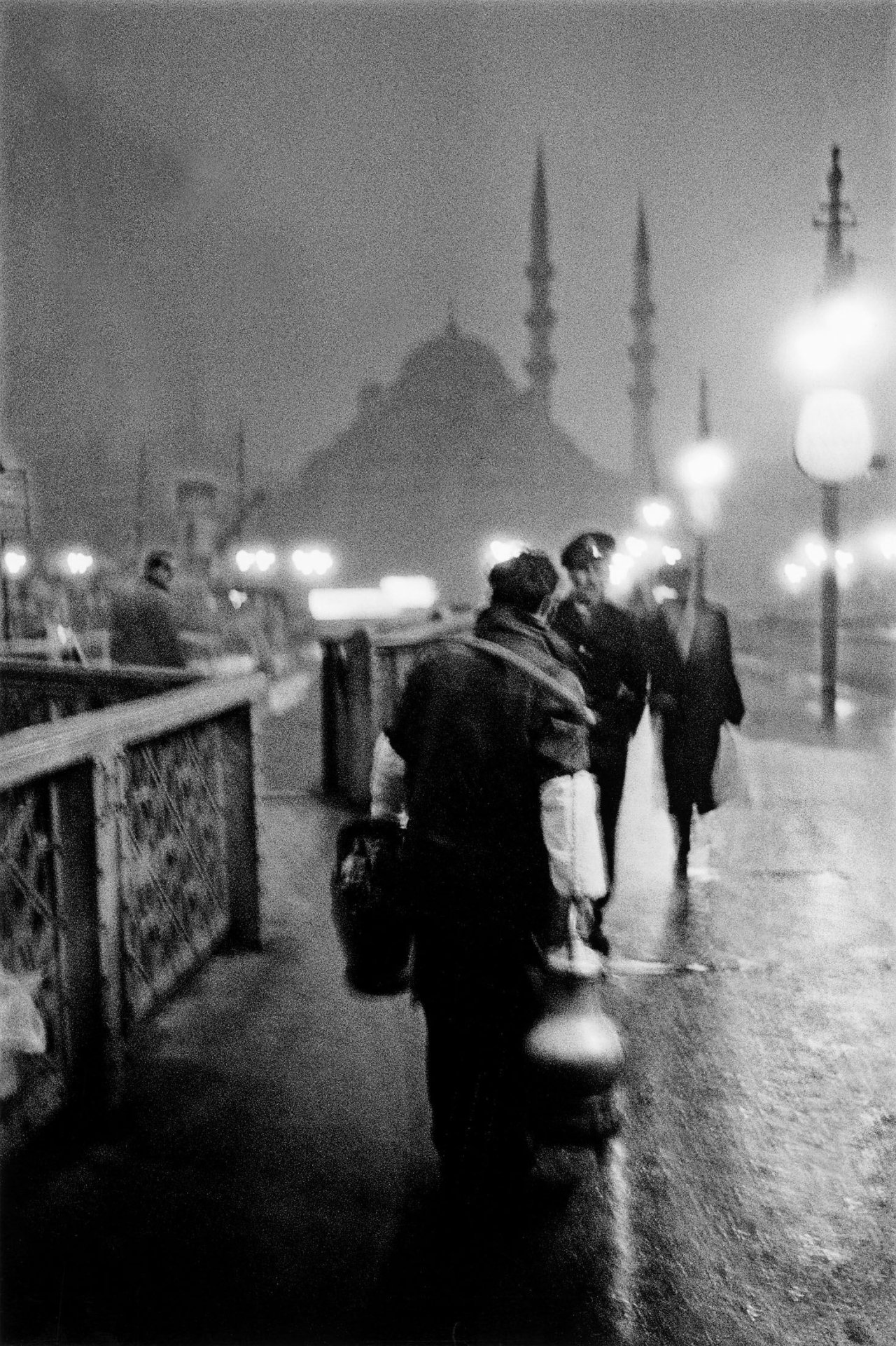 Auf diesem Bild ist das folgende Kunstwerk zu sehen: Ara Güler. Salep-Verkäufer im Morgengrauen auf der alten Galata-Brücke, Istanbul. 1957.