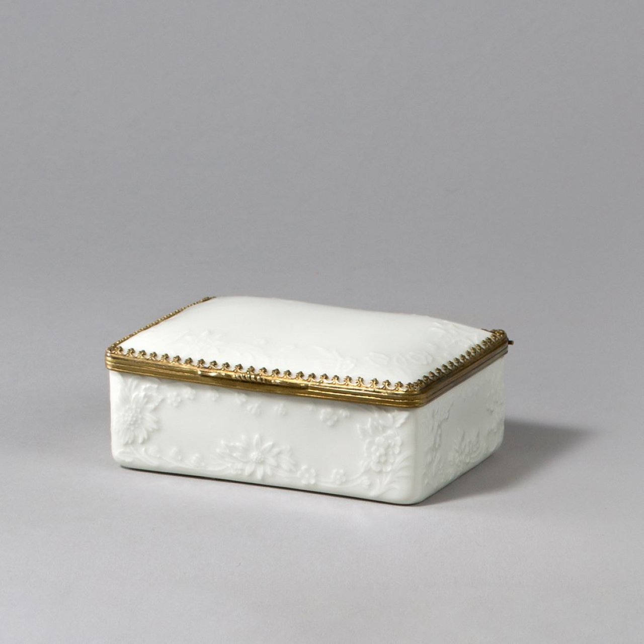 Auf diesem Bild ist das folgende Kunstwerk zu sehen:  KPM Königliche Porzellan-Manufaktur Berlin. Tabatière mit reliefiertem Blumendekor und Goldbronzemontierung. Um 1770.