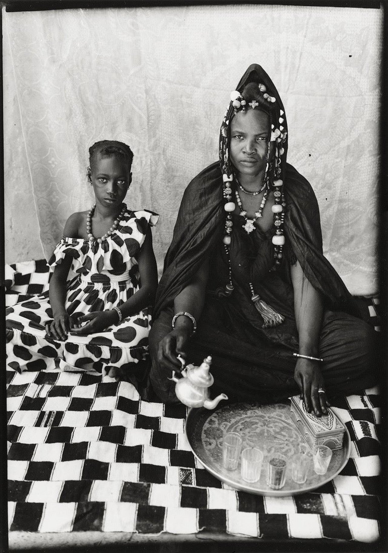 This picture shows the following artwork: Seydou Keïta. Maurische Haratine-Frau mit Tochter auf einer karierten Decke (koso walan). 1949–1951.