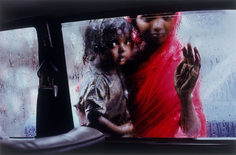 Auf diesem Bild ist das folgende Kunstwerk zu sehen: Steve McCurry. Mother and Child at Car Window, Bombay, India. 1993.
