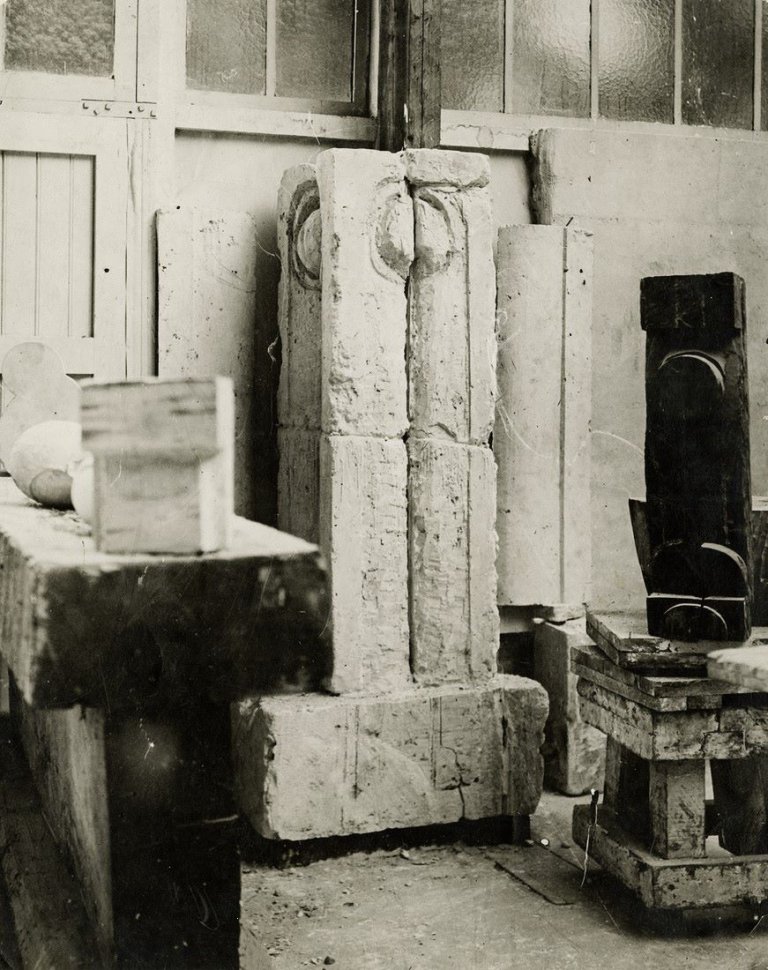 Auf diesem Bild ist das folgende Kunstwerk zu sehen: Constantin Brâncuşi. „La Colonne du Baiser, fragment“ (Atelieransicht). Um 1917.