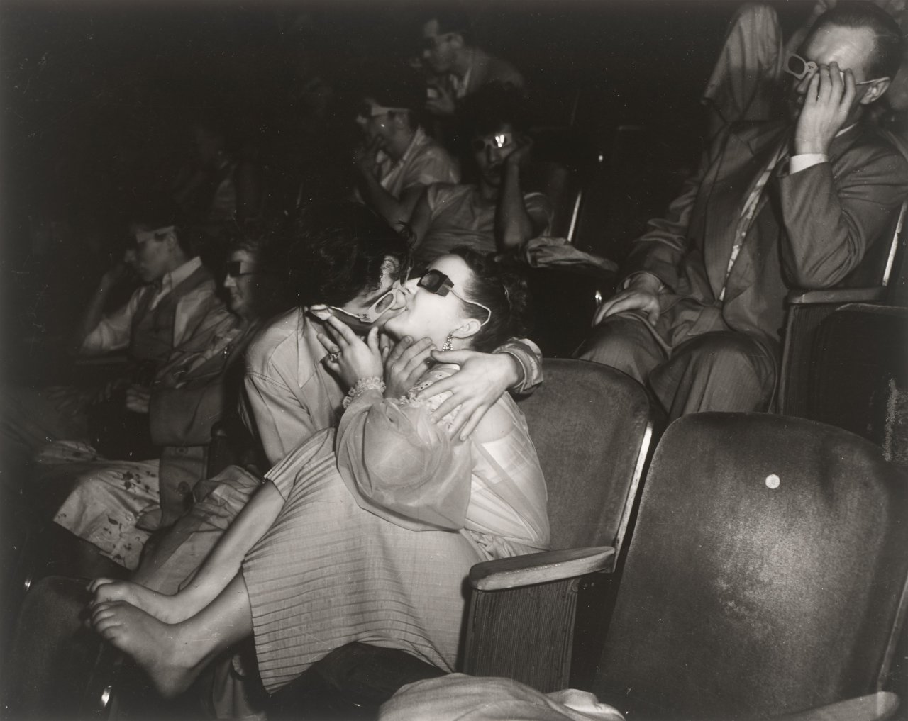 Auf diesem Bild ist das folgende Kunstwerk zu sehen:  Weegee (d.i. Fellig, Arthur H.). 'Lovers', Palace Theater, New York City. 1945.