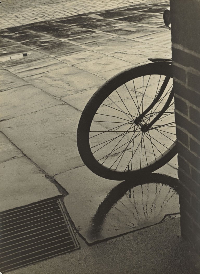 Auf diesem Bild ist das folgende Kunstwerk zu sehen: Herbert List. Fahrrad an der Ecke, Hamburg. Um 1930.