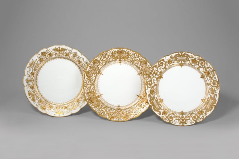 Auf diesem Bild ist das folgende Kunstwerk zu sehen:  KPM Königliche Porzellan-Manufaktur Berlin. Zierteller Augustaform mit Harpien und Fruchtkörben in Reliefgold. Um 1900/10.