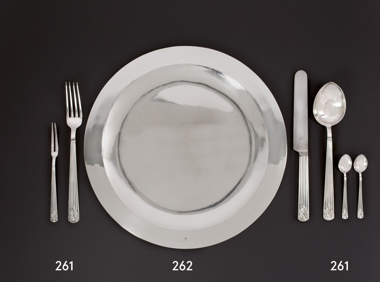 Auf diesem Bild ist das folgende Kunstwerk zu sehen: Emil Lettré. Sechsteiliges „Tafel-Besteck der Reichs-Hauptstadt“ – bestehend aus einer Fleischgabel, Speisegabel und -messer, Suppenlöffel sowie zwei Mokkalöffeln. 1928.