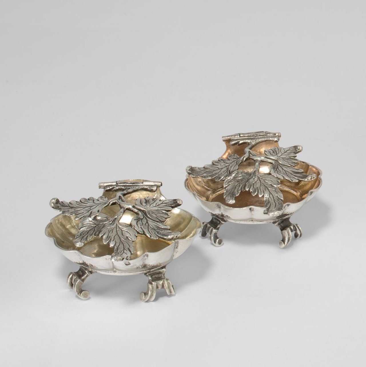 Auf diesem Bild ist das folgende Kunstwerk zu sehen:  Stettin. Paar Konfektschälchen mit freiplastischem Blattzweigdeckel von Paul Miercke (1714–1784). Um 1775/80.