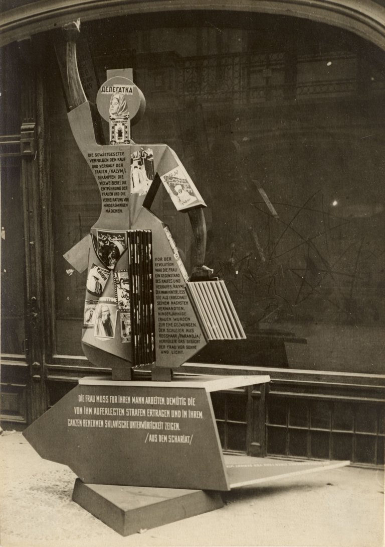 Auf diesem Bild ist das folgende Kunstwerk zu sehen: El Lissitzky. Figurine von Michail Plaksin für den Sowjet-Pavillon in der Abteilung „Die Frau und die Presse“ auf der Internationalen Presse-Ausstellung „Pressa“ in Köln. Ausstellungsarchitekt: El Lissitzky. Probeaufstellung im Staatlichen Kaufhaus GUM, Moskau. 1928.