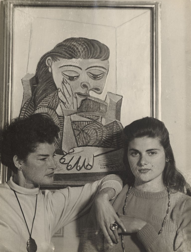 Auf diesem Bild ist das folgende Kunstwerk zu sehen: Florence Homolka. Juliet Browner (Ray) und ihre Schwester Selma vor dem Gemälde „Lesendes Mädchen“ von Pablo Picasso. 1946.