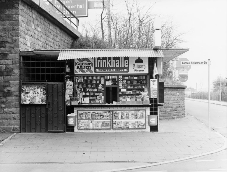 Auf diesem Bild ist das folgende Kunstwerk zu sehen: Tata Ronkholz. Leverkusen, Gustav-Heinemann-Strasse, aus der Serie „Trinkhallen“, 1977–1984. 1979.