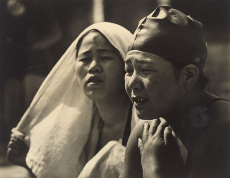 Auf diesem Bild ist das folgende Kunstwerk zu sehen: Leni Riefenstahl. Japanerinnen beobachten den Kampf ihrer Landsleute. 1936.