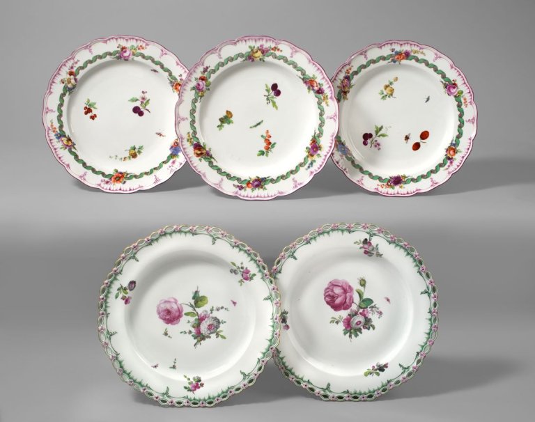 Auf diesem Bild ist das folgende Kunstwerk zu sehen:  KPM Königliche Porzellan-Manufaktur Berlin. Drei Teller Neuglatt mit grünem Spiralband um gestreiften Purpurring mit Blumen- und Früchtemalerei. Um 1780/85.