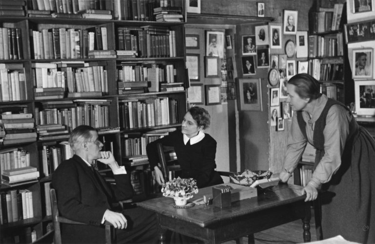 Auf diesem Bild ist das folgende Kunstwerk zu sehen: Gisèle Freund. James Joyce mit Adrienne Monnier und Sylvia Beach in der Buchhandlung Shakespeare & Co., Paris. 1938.