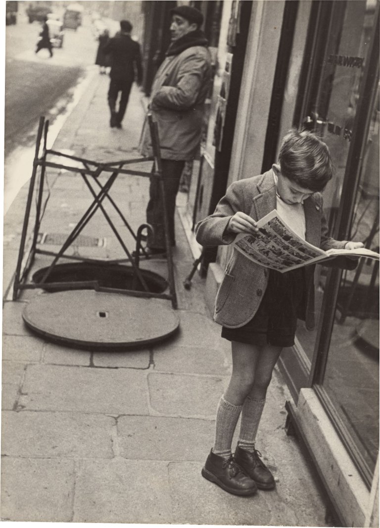 Auf diesem Bild ist das folgende Kunstwerk zu sehen: Louis Stettner. „Boy reading Comics, Paris“. 1951.