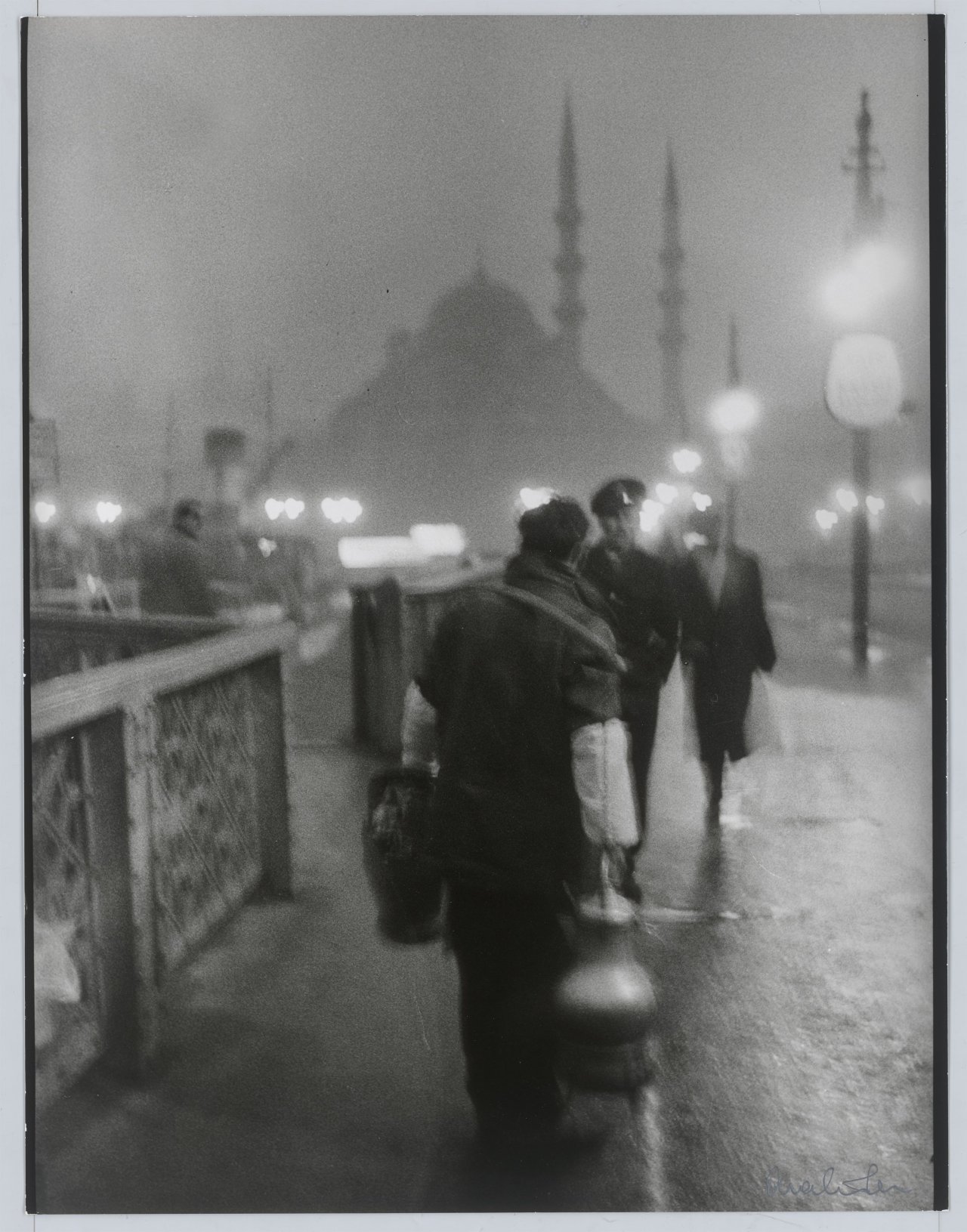 This picture shows the following artwork: Ara Güler. 'Salep' Seller in early morning light on the old Galata Bridge. 1957.