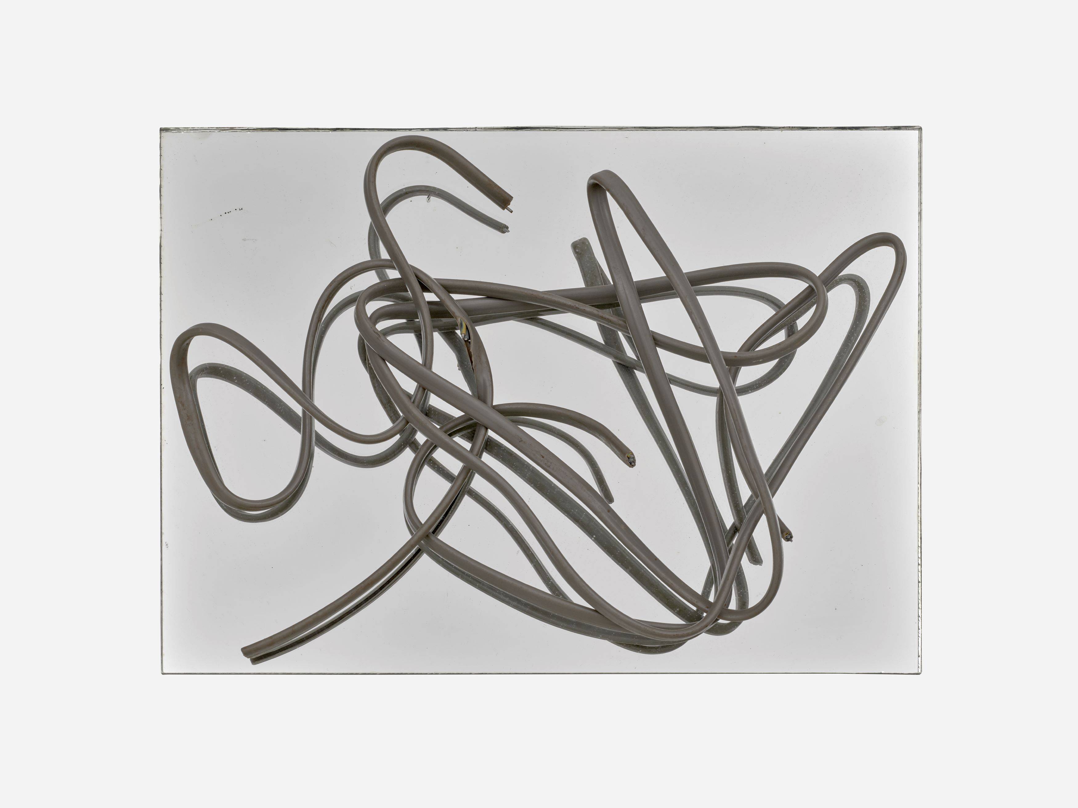 Auf diesem Bild ist das folgende Kunstwerk zu sehen: Hermann Glöckner. Grau ummanteltes, dreiadriges Aluminiumkabel auf Spiegel.