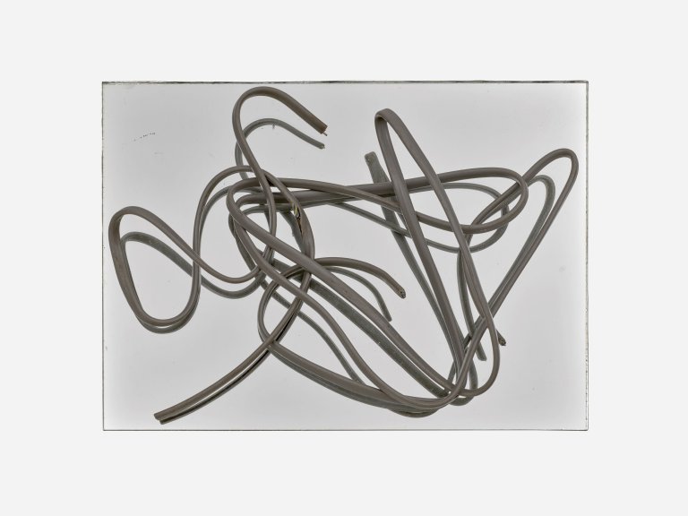 Auf diesem Bild ist das folgende Kunstwerk zu sehen: Hermann Glöckner. Grau ummanteltes, dreiadriges Aluminiumkabel auf Spiegel.