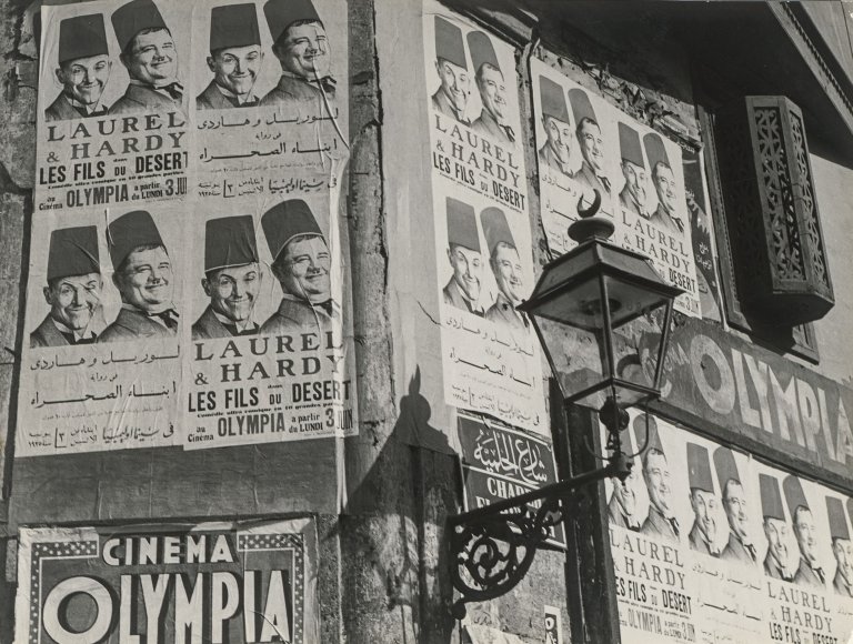Auf diesem Bild ist das folgende Kunstwerk zu sehen: Willem van de Poll. Straßenleben Cairo, Filmreklame. 1935.