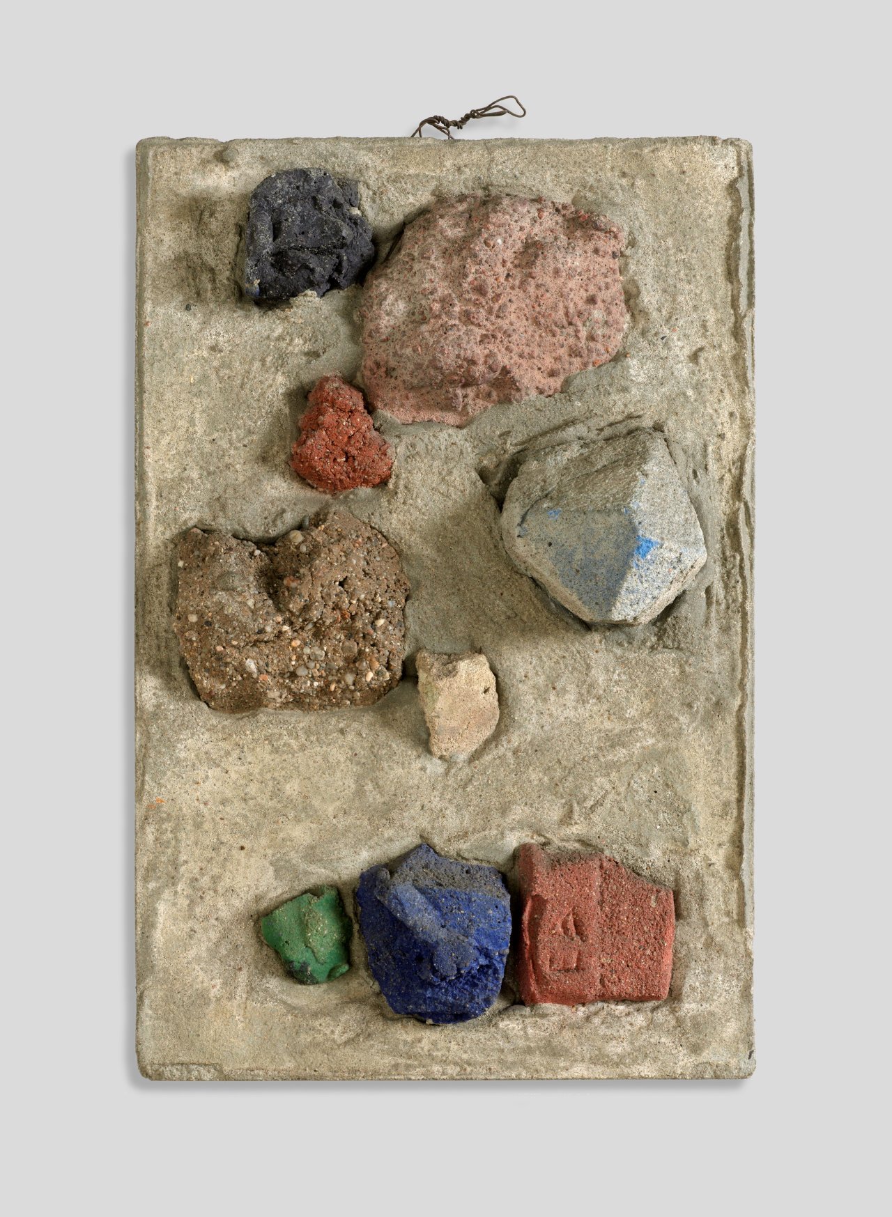 Auf diesem Bild ist das folgende Kunstwerk zu sehen: Hermann Glöckner. Neun Mörtelbrocken im Relief. 1960.