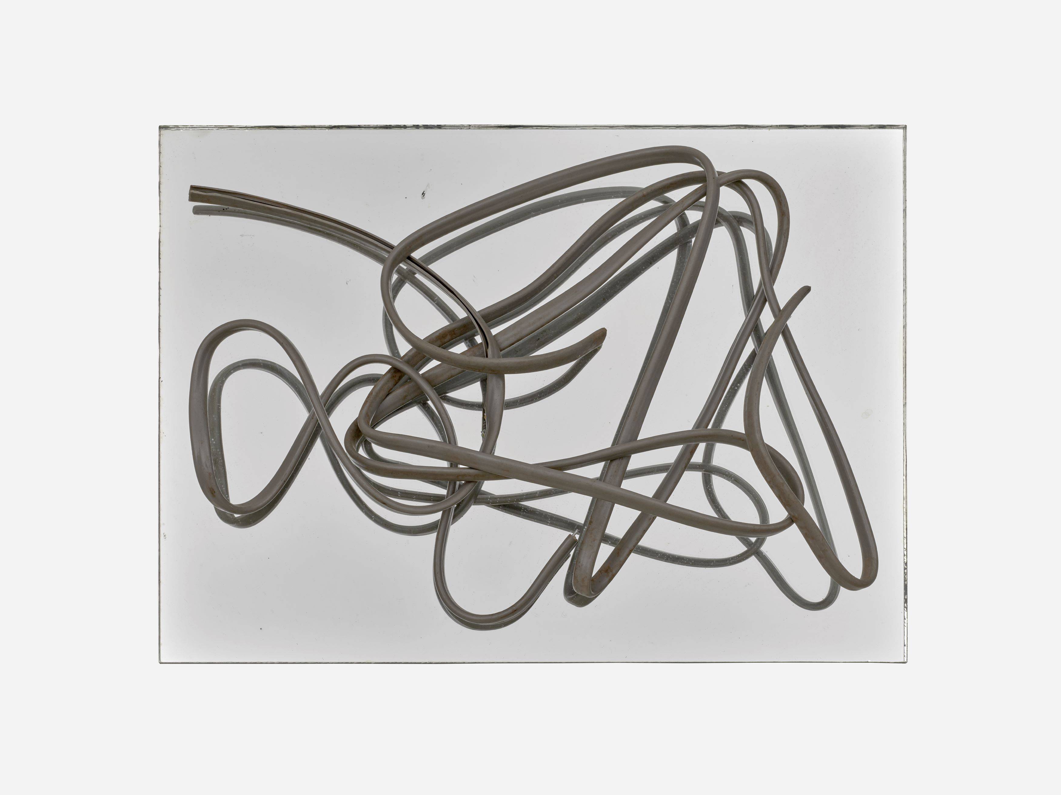 Auf diesem Bild ist das folgende Kunstwerk zu sehen: Hermann Glöckner. Grau ummanteltes, dreiadriges Aluminiumkabel auf Spiegel.