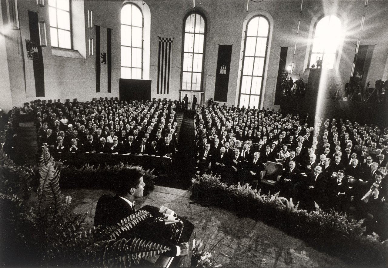 Auf diesem Bild ist das folgende Kunstwerk zu sehen: Will McBride. „John F. Kennedy spricht in der Paulskirche, Frankfurt am Main“. 1963.