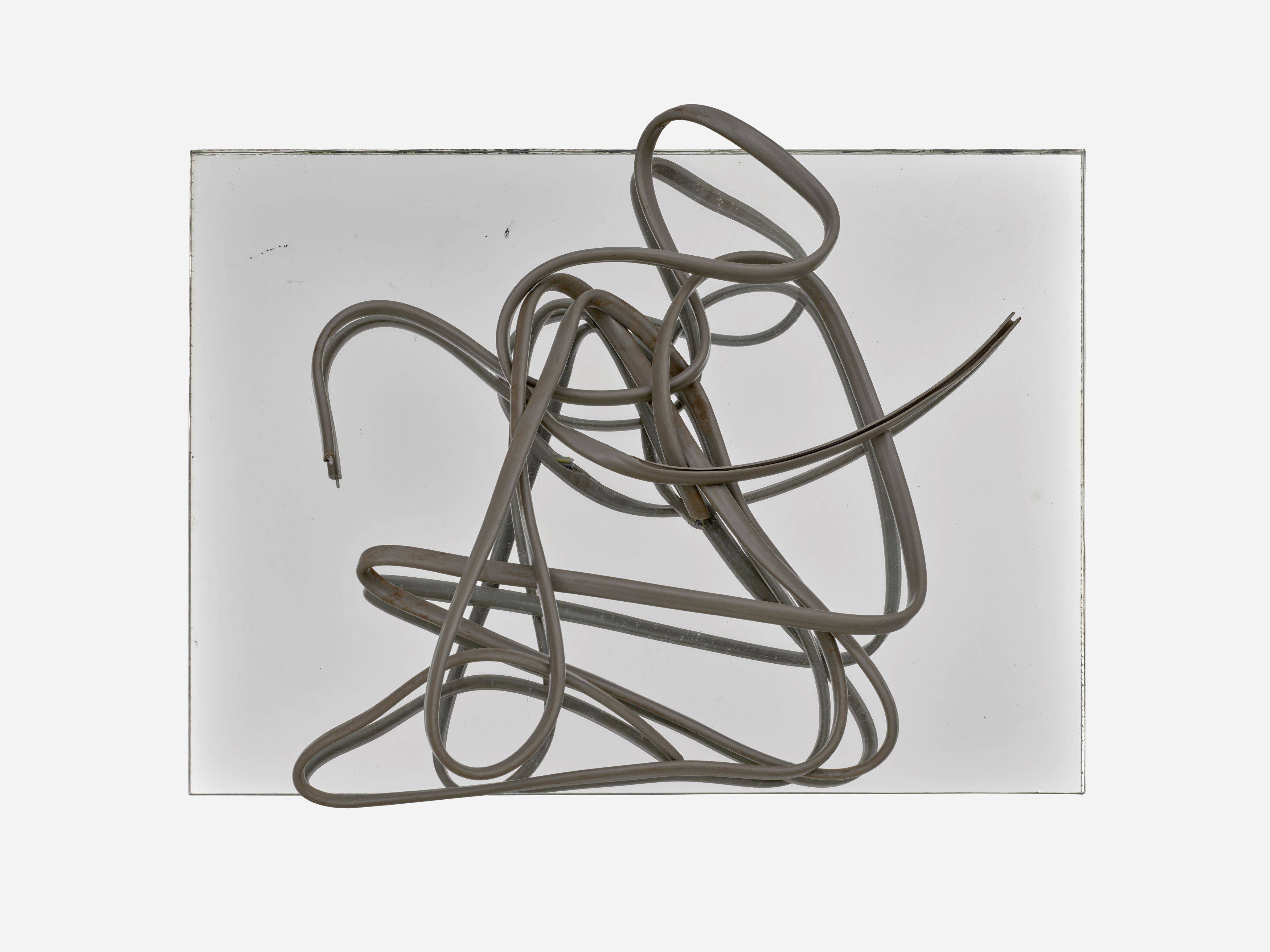 Auf diesem Bild ist das folgende Kunstwerk zu sehen: Hermann Glöckner. Grau ummanteltes, dreiadriges Aluminiumkabel auf Spiegel.