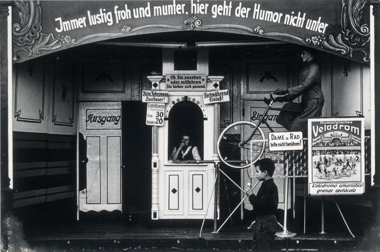 Auf diesem Bild ist das folgende Kunstwerk zu sehen: Herbert List. Humoristisches Velodrom auf dem Oktoberfest, München. 1956.